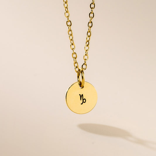 A gold-plated pendant necklace with a gold chain, featuring the zodiac sign Capricorn engraved on a 10mm diameter pendant.