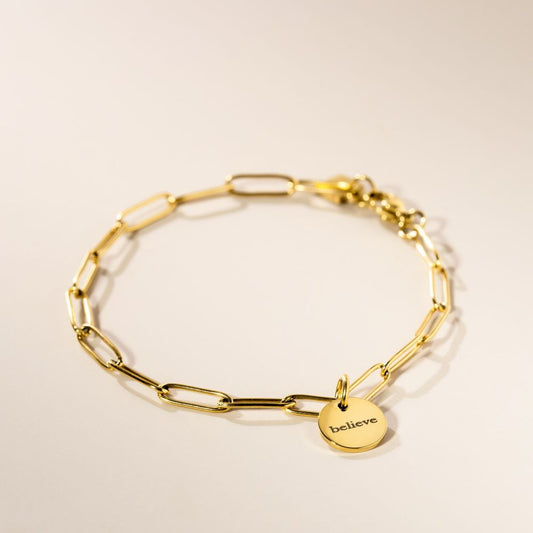 A gold-plated link bracelet with a personalized engraved pendant on a white background.