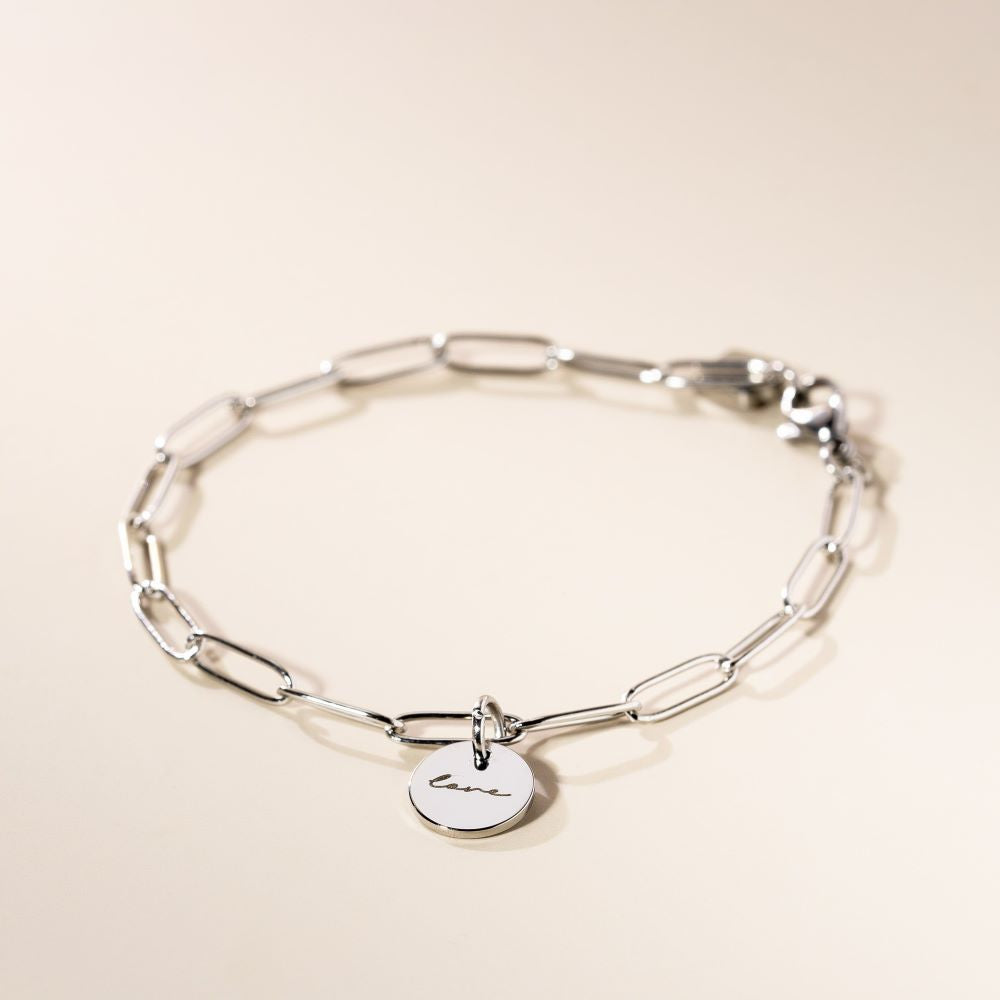 A chain silver bracelet with an engraved piece