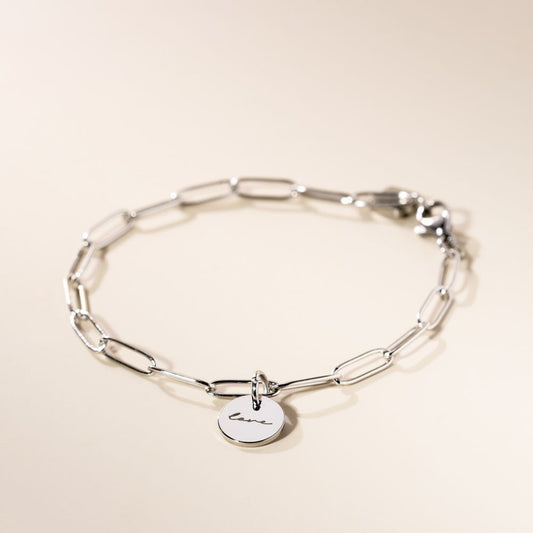 A chain silver bracelet with an engraved piece