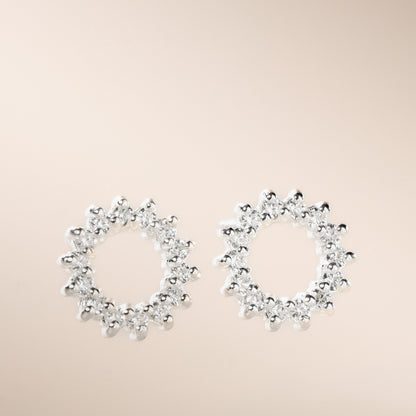 A pair of silver-colored open circle stud earrings with cubic zirconia stones