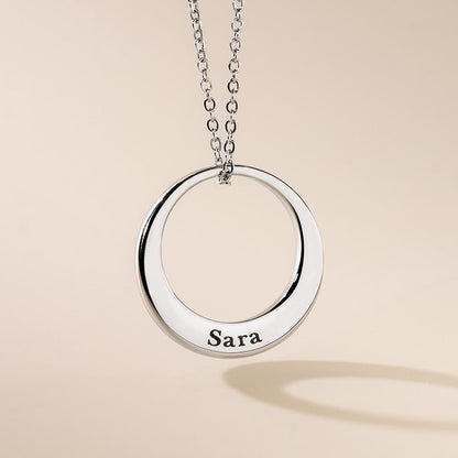 A silver small washer pendant engraved with name