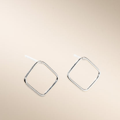 A pair of silver open square stud earrings displayed against a neutral background.