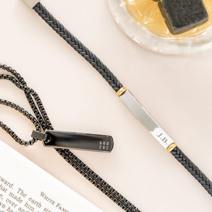 A long black pendant necklace and a leather bracelet