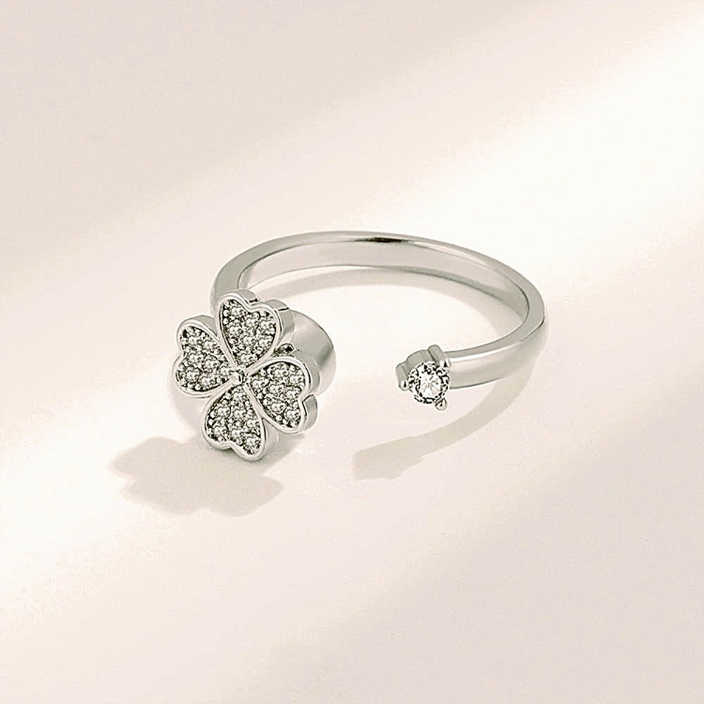 Silver ring with a clover-shaped diamond design on a light background