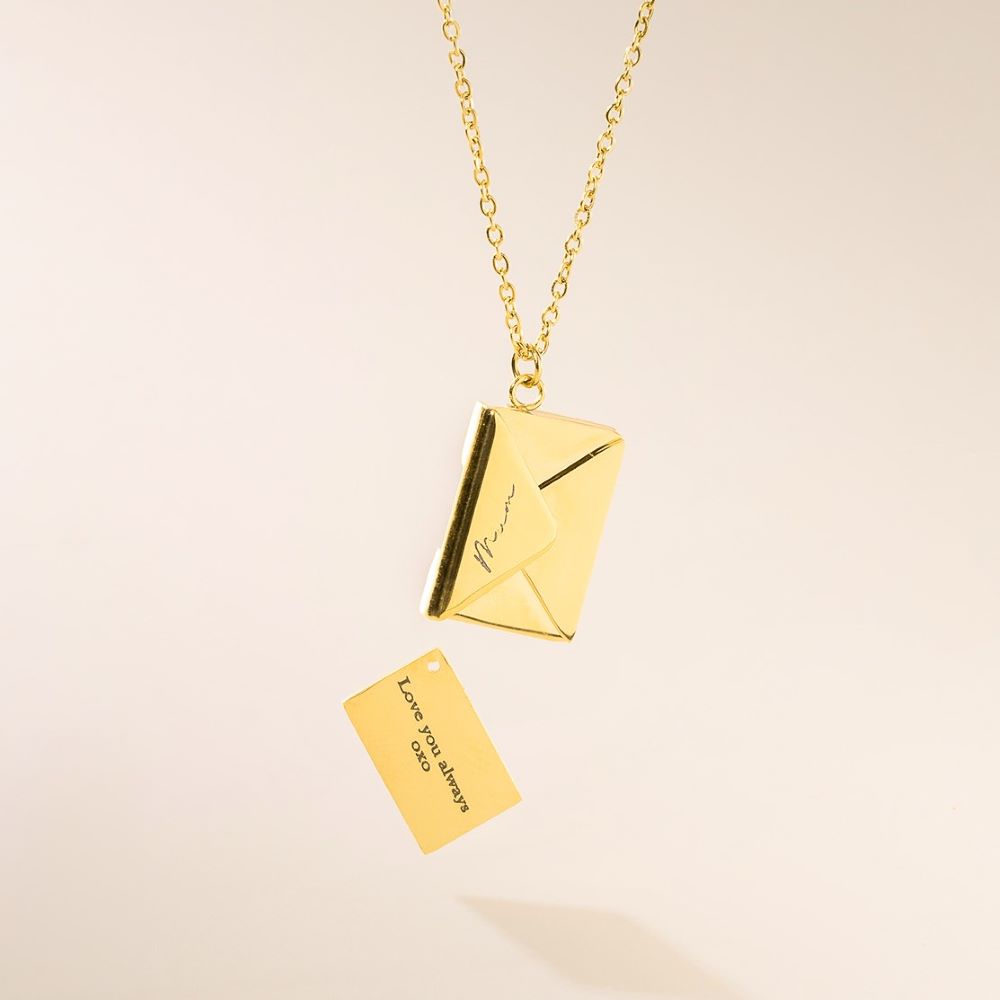 A gold necklace with a letter pendant