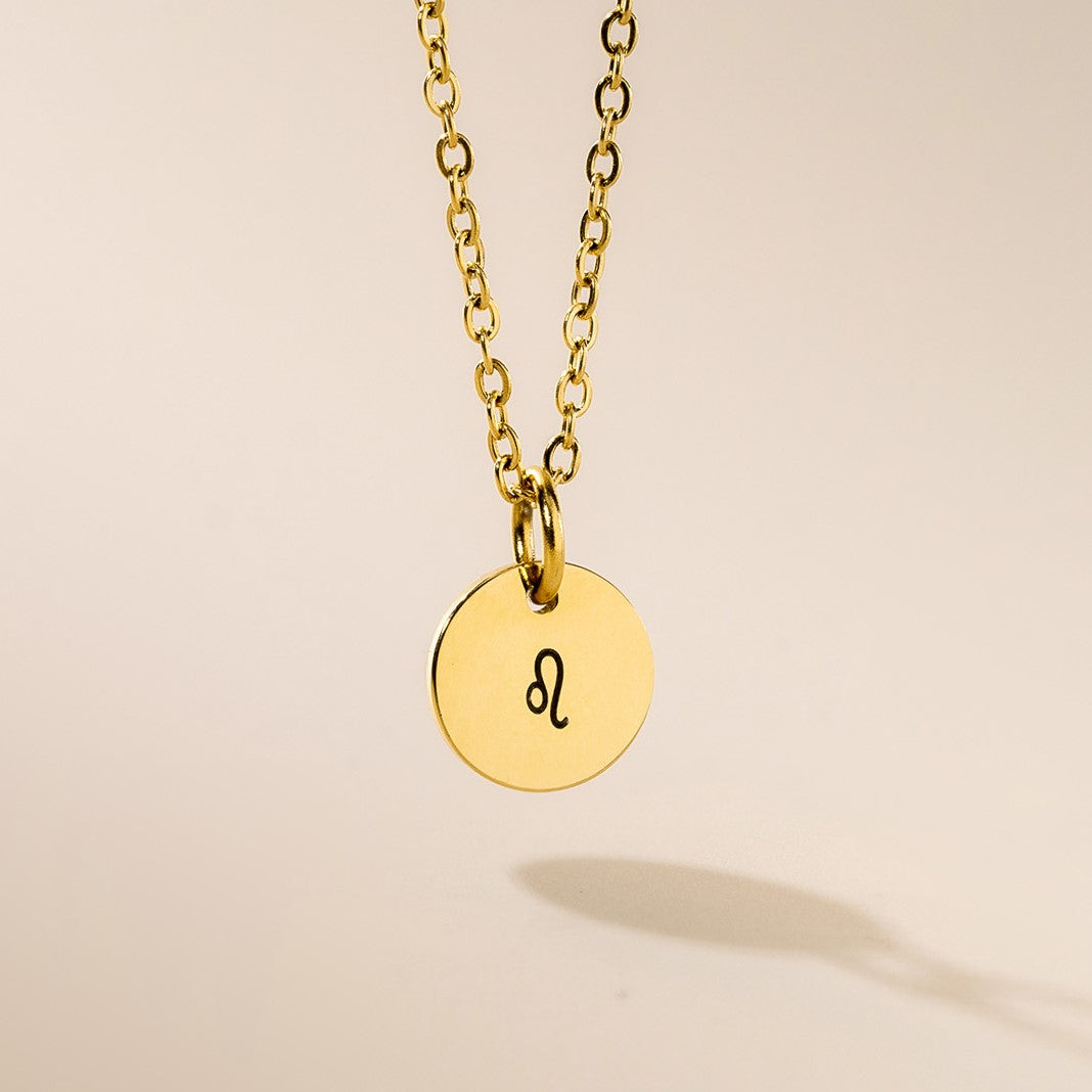A gold necklace with Leo sign pendant