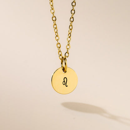 A gold necklace with Leo sign pendant