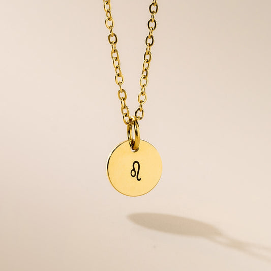 A gold necklace with Leo sign pendant