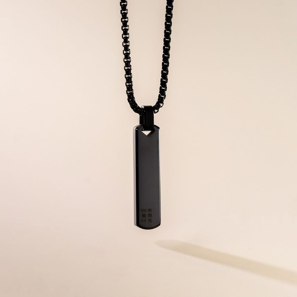 A sleek black pendant necklace with a box chain displayed against a neutral background.