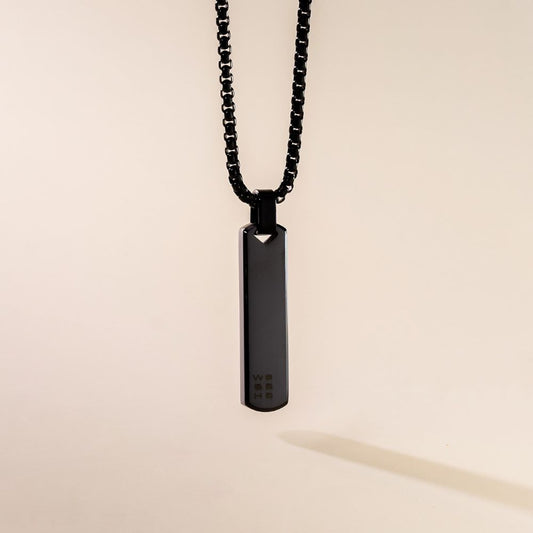 A sleek black pendant necklace with a box chain displayed against a neutral background.