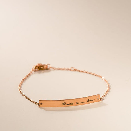A rose gold bracelet with an engraved piece