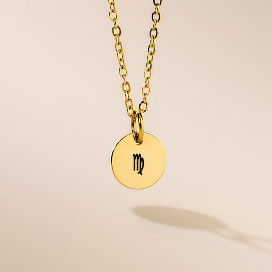 A gold necklace with Virgo sign pendant