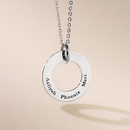 A silver-colored necklace with a round pendant featuring the engraved text 'Aiyahh Phoenix' on a chain.