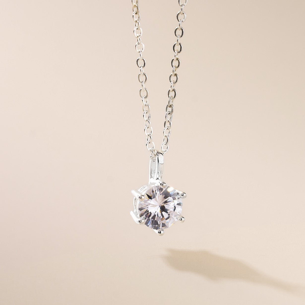 A silver-colored necklace featuring a cubic zirconia pendant at the center, with a classic design and a length of 45cm.
