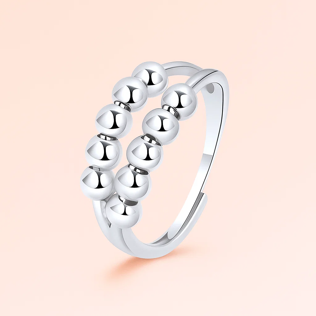 Silver ring with bead design on a light pink background