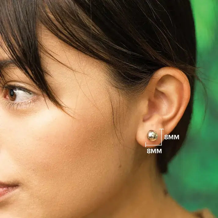 Close-up of a person wearing a ball stud earring with size measurement labels.