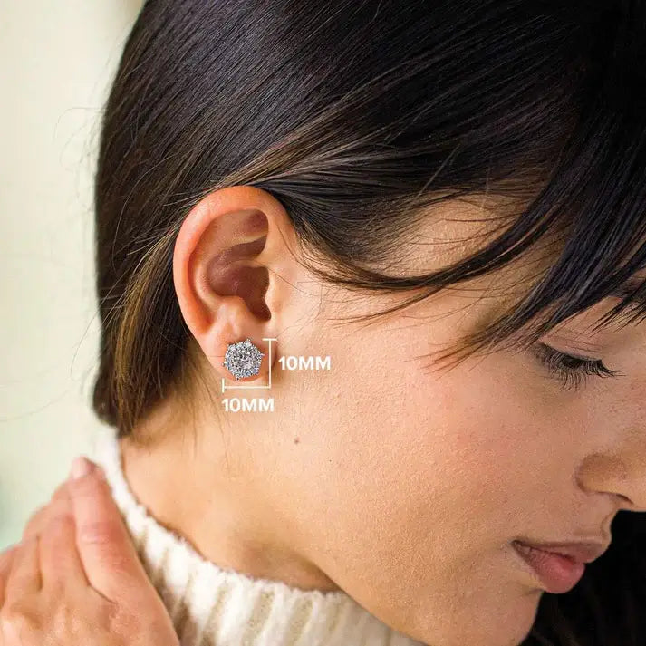 Close-up of a person wearing a silver earring with a clear gemstone, set against a neutral background.