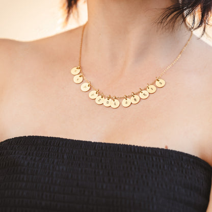 A girl wearing a necklace with all horoscope pendants