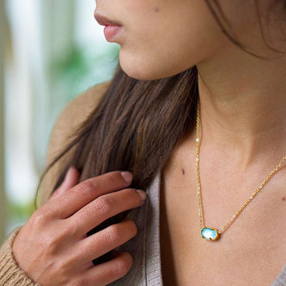 A woman wearing an oval stone pendant necklace