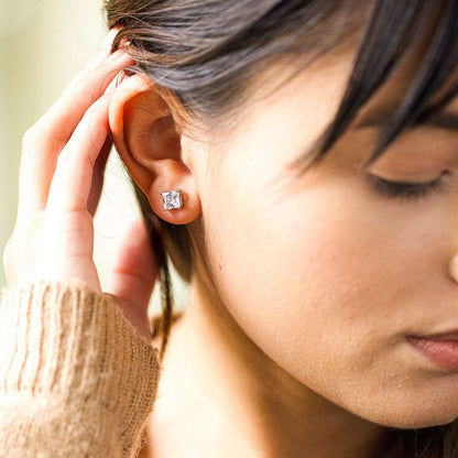 A girl wearing square cubic zirconia stud earrings